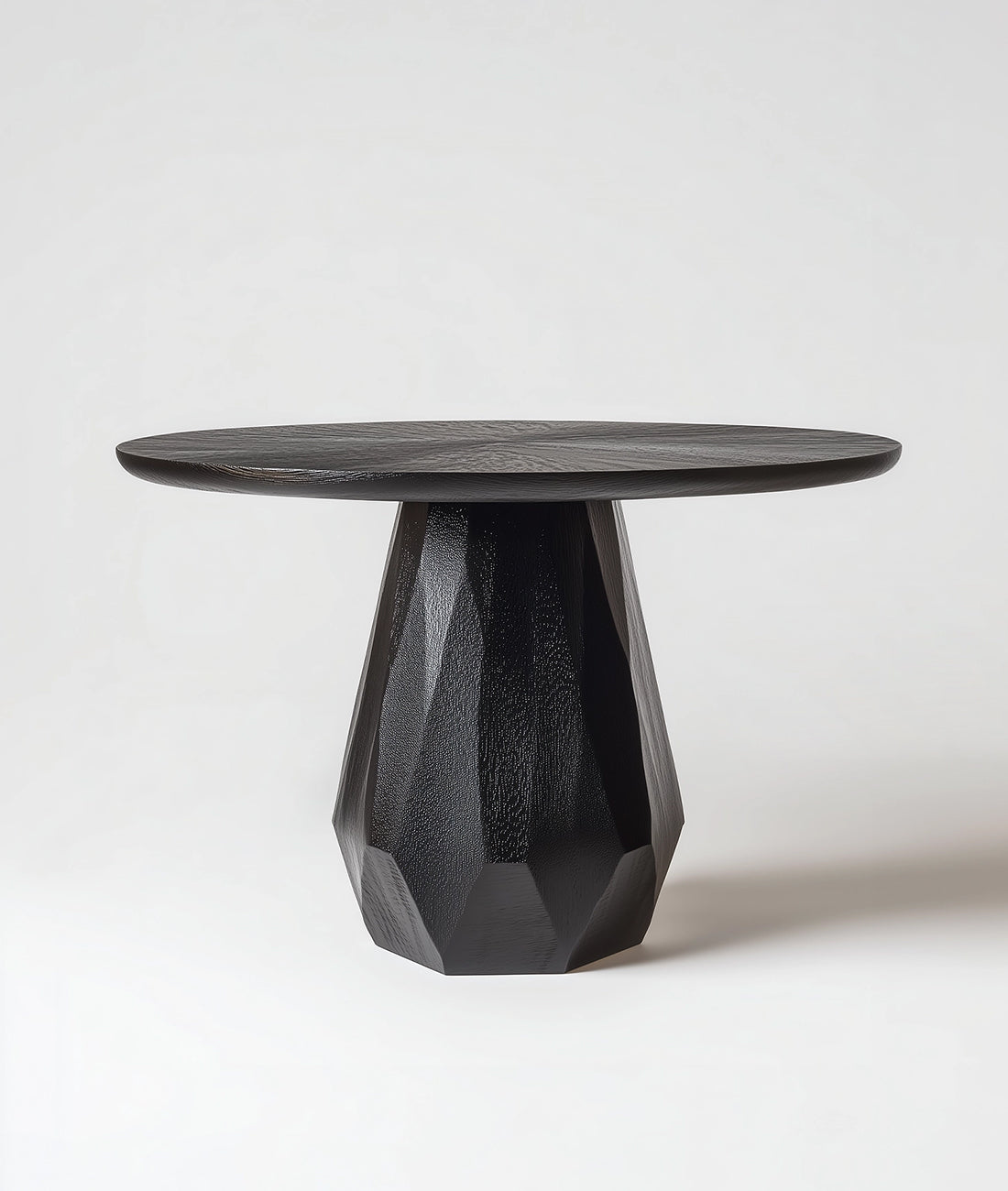 Black side table with geometric base on a white background